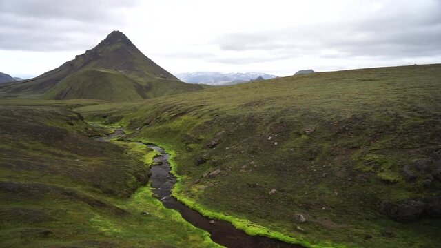 Green field with moss and mountain peak on the Laugavegur hiking trail, Iceland