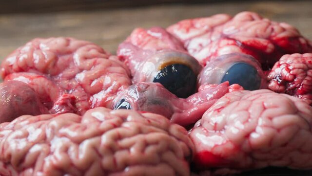 raw brains on a plate with big eyeballs. the concept of a spooky dish for the Halloween holiday.
