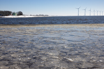 Fototapeta Dutch winter with sea covered with drift ice and waves obraz
