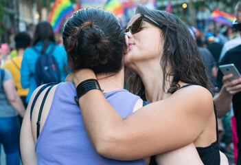 A girl giving a kiss in the cheek to another girl in the Buenos Aires gay parade - Argentina