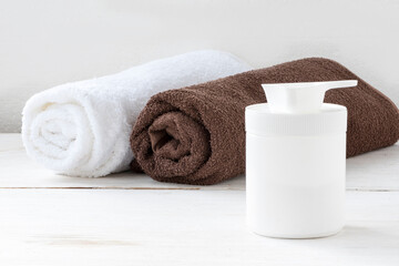 Obraz na płótnie Canvas Clean white and brown towel on a roll with a container of laundry powder
