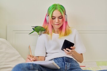 Bright beautiful owner of parrot teenager student with pet on her shoulder