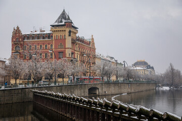 Bellevue house in the style of the Dutch renaissance and Smetana Museum at Smetana embankment, Old town and Vltava river, snow in winter day, Prague, Czech Republic