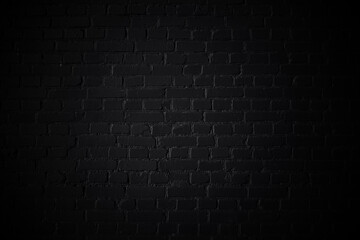 Black background. Brick wall texture with vignette. Monochrome photo.