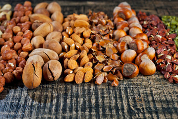 Many kinds of nuts close up. Heap of nuts on a black wooden board. Nuts are stacked on the table.