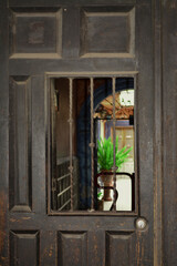 Puerta rústica de madera con ventana al fondo vista de patio trasero