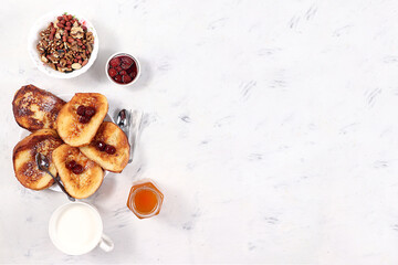 Fototapeta na wymiar French toast and muesli on a gray table with berries and jam. Delicious healthy French breakfast. Top view, place for text. Minimalistic concept of a modern bakery. Selective focus