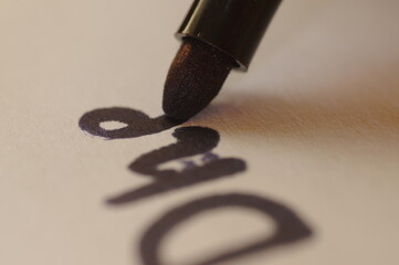 Learning to write and draw - close-up of a stylus arrowhead with writing and drawing. Graphology...