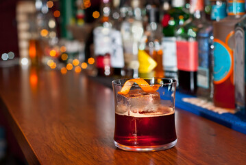 Yellow cocktail on bar counter. Whiskey, rum or brandy on the background of bottles with alcohol....