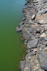 Orilla de lago con aguas tranquilas y rocas