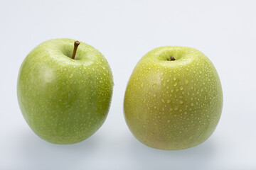 Green apples with water drops, isolated on white background