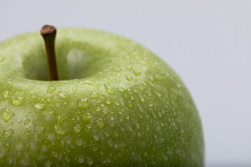 Green apple with water drops, isolated on white background