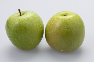 Green apples with water drops on white background