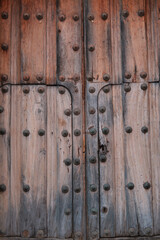 Textura de madera antigua con herrajes de acero oxidados en portón de iglesia de pueblo