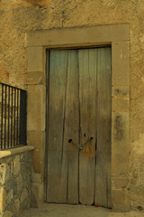 Antigua puerta de madera desgastada y podrida con marco de cantera