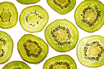 Ripe and green kiwi sliced with seeds visible on white background