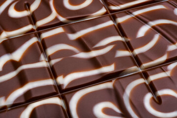 Milk chocolate bar close up. White and dark chocolate. Chocolate texture.