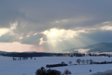 Sun rays passing through clouds in winter 