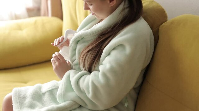Bright portrait of happy mum. Manual breast pump and bottle for milk. Mother pumping breast milk on the bed in bedroom. Pump milk concept.
