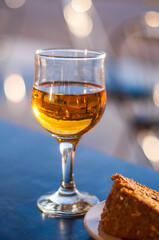 A glass of white dessert wine on a table in a cafe