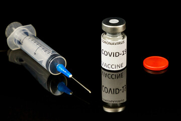 Vaccine bottle withred cap and label Covid - 19 Coronavirus Vaccine, medical syringe isolated on...