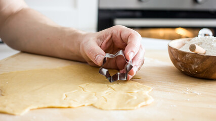 The process of making homemade asterisk shortbread cookies. Male hands cut cookies using a mold...