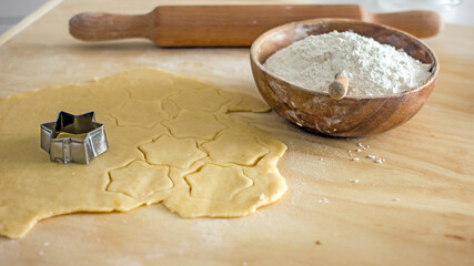 The process of making homemade asterisk shortbread cookies. Male hands cut cookies using a mold made of rolled dough. Authentic home hobby