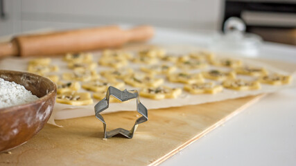 The process of making homemade asterisk shortbread cookies. Male hands cut cookies using a mold...
