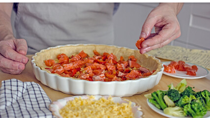 A man in the kitchen bakes a fish pie quiche close-up