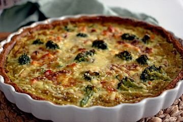 Homemade French quiche pie with salmon and broccoli in a baking dish close-up