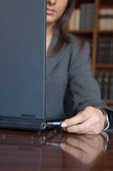 Giovane donna in ufficio lavora con il computer e una chiavetta