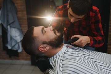 Young Bearded Man Getting Beard Haircut By Barber. Barbershop Theme