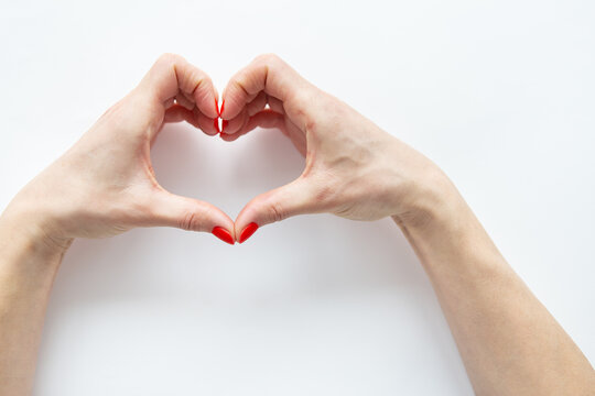 Female hands in the shape of a heart isolated on white background. The concept of care and love.