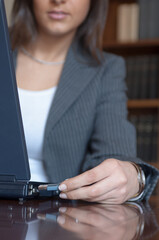 Dettaglio di una mano di donna che inserisce la chiavetta nel computer portatile