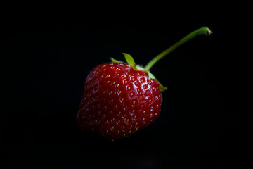Strawberry close-up, on a black background, artistic selective focus