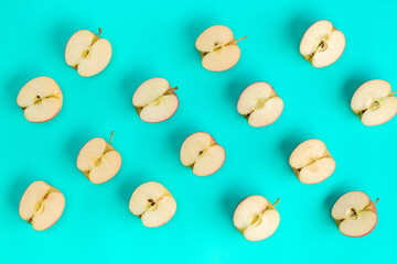 Fruit pattern of apple halves on blue background. Flat lay, top view. Food background. .  Pop art design, creative summer concept.