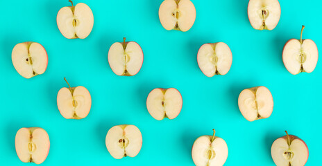 Fruit pattern on blue background. Apple halves geometrical layout. Flat lay, top view. Food background. .  Pop art design, creative summer concept.