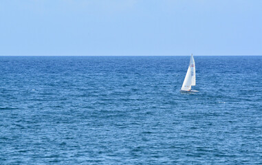 Una barca a vela naviga sul mare blu.