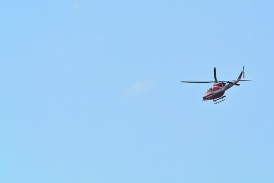 Un elicottero dei Vigili del Fuoco italiani in volo nel cielo blu.