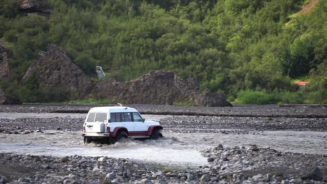 Car 4x4 driving by through fast flew river in Thorsmork, Iceland. Adventure 
