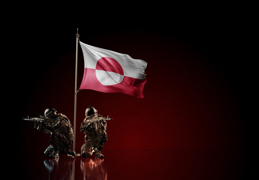 Concept of military conflict. Waving national flag of Greenland. Illustration of coup idea. Two soldier statue guards defending the symbol of country against red wall
