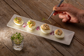 Fototapeta na wymiar delicius Stuffed eggs with han serving and sprouts