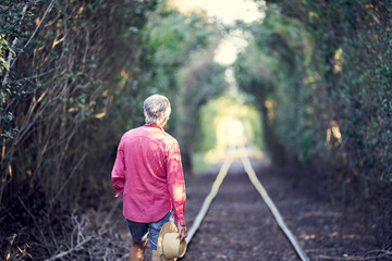 View Of Man Standing At Entrance Of Tunnel In Forest