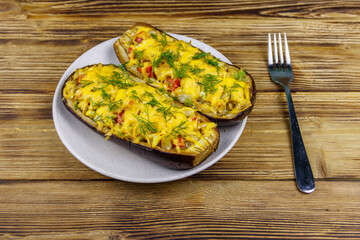 Baked stuffed eggplants on a wooden table. Healthy food and dieting concept