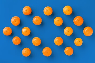 Fruit pattern of fresh orange tangerine or mandarin on blue background. Flat lay, top view. Pop art design, creative summer concept. Citrus in minimal style.