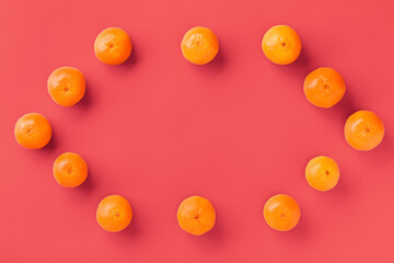 Fruit pattern of fresh orange tangerine or mandarin on living coral background. Flat lay, top view. Pop art design, creative summer concept. Citrus in minimal style.