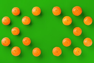 Fruit pattern of fresh orange tangerine or mandarin on green background. Flat lay, top view. Pop art design, creative summer concept. Citrus in minimal style.