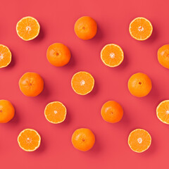 Fruit pattern of fresh orange tangerine or mandarin on living coral background. Flat lay, top view. Pop art design, creative summer concept. Citrus in minimal style.