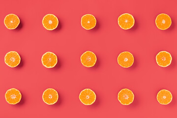 Fruit pattern of fresh orange tangerine or mandarin on living coral background. Flat lay, top view. Pop art design, creative summer concept. Citrus in minimal style.