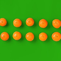 Fruit pattern of fresh orange tangerine or mandarin on green background. Flat lay, top view. Pop art design, creative summer concept. Citrus in minimal style.